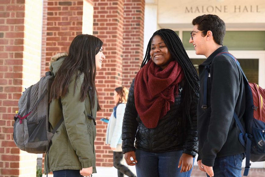 Malone Hall exterior with students smiling